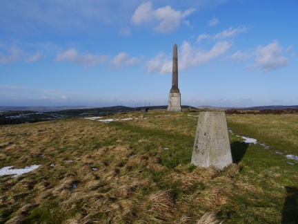 The trig point on Bishop Park with the monument behind